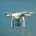 Drohne fliegt vor blauem Himmel